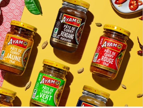 Ayam Brand curry paste jars styled on a yellow background.
